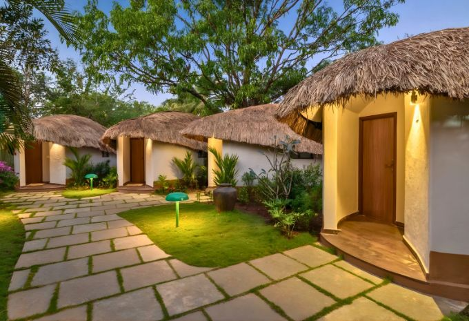 Exterior of the thatched boutique villa with arched architecture at Mercure Goa Devaaya Resort